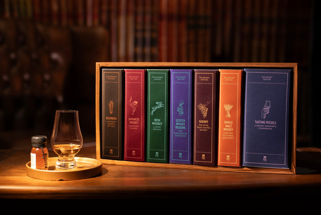 The Dramthology Bookshelf: seven whisky books on a wooden shelf